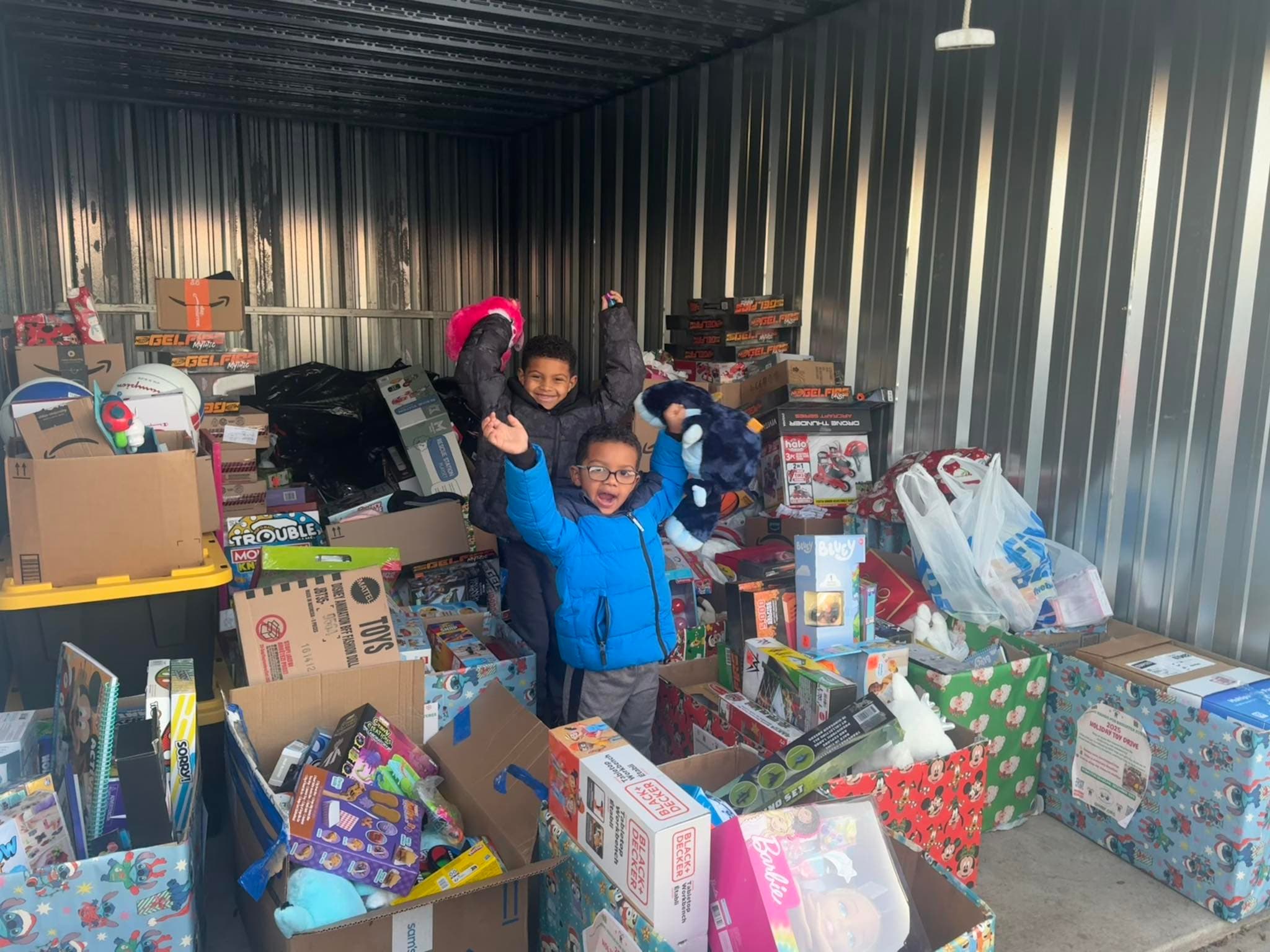 Julius and Braydon surrounded by donated toys